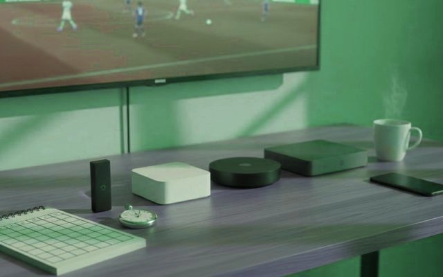 Five streaming devices, a notebook scoring grid and a stopwatch in front of a TV showing a football match