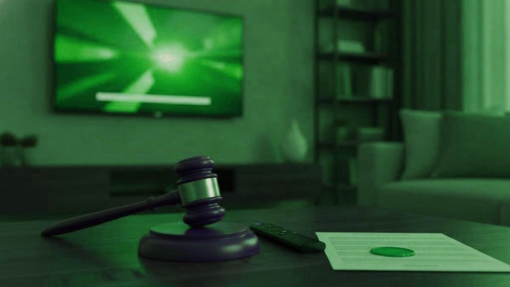 A judge gavel, a streaming remote and a sealed document on a coffee table in front of a TV